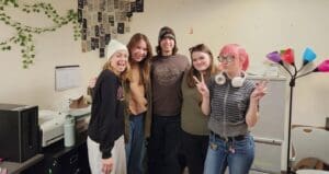 Five friends smiling for a photo.