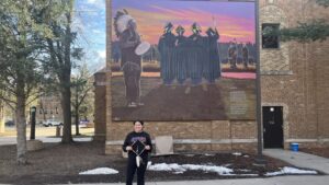 Native American mural with graduate figures.