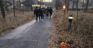 People walking on path with carved pumpkins.