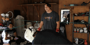 People training and laughing in a gym.