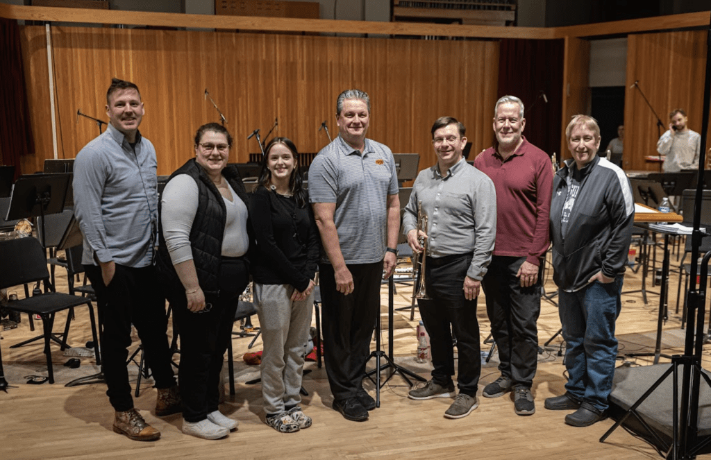 Group of people standing in a studio.