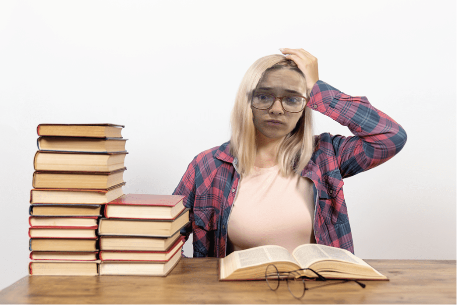 Woman stressed with studying and many books.
