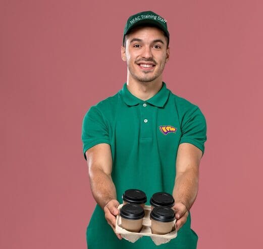 Man holding coffee tray, wearing green uniform.