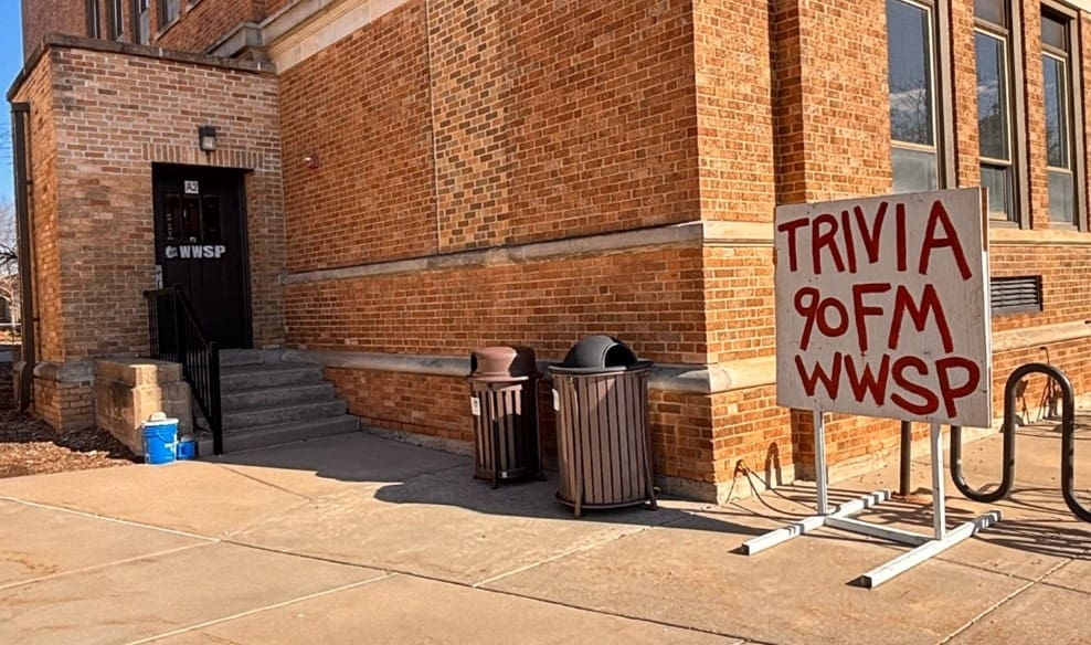 Building entrance with trivia sign outside.