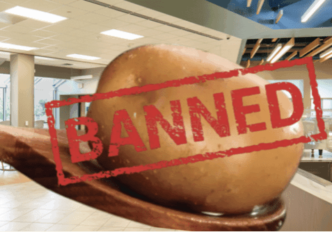 Potato on spoon labeled "Banned" in cafeteria.