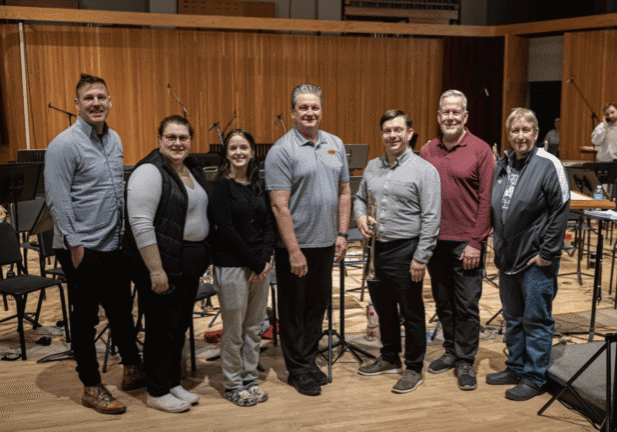 Group of people standing in a studio.