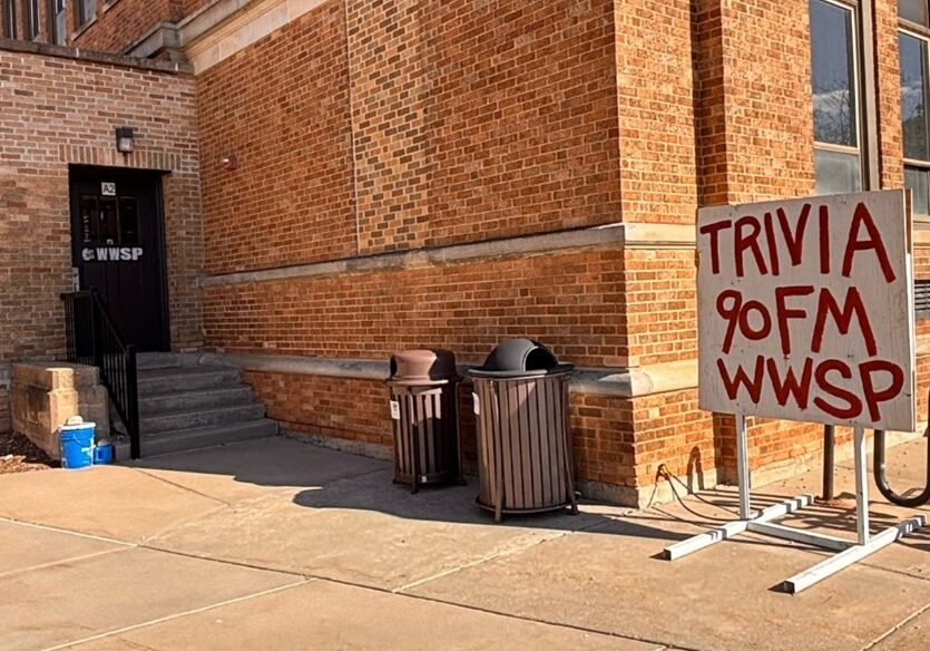 Building entrance with trivia sign outside.